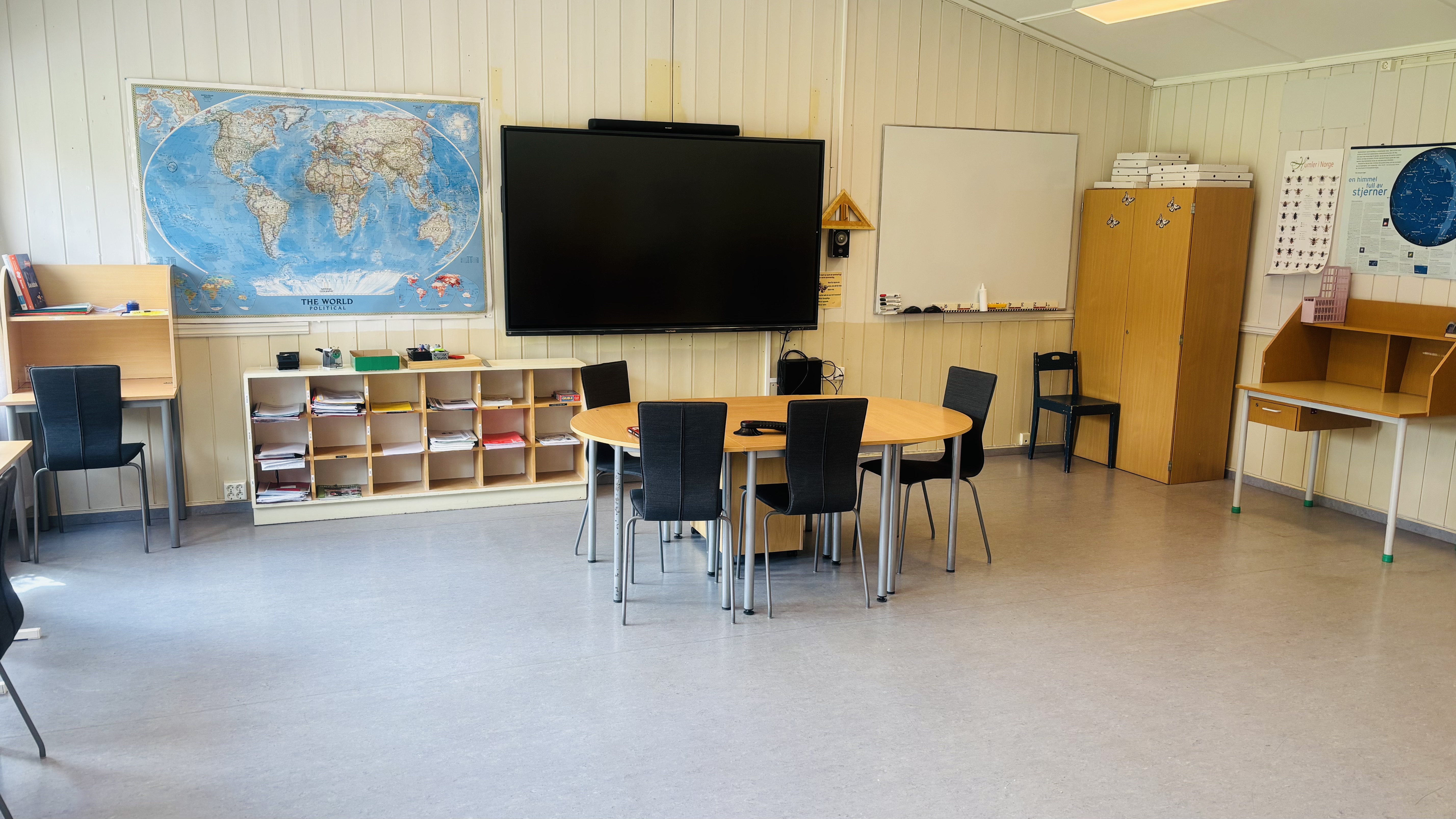 et klasserom med pulter og stoler