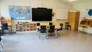 et klasserom med pulter og stoler