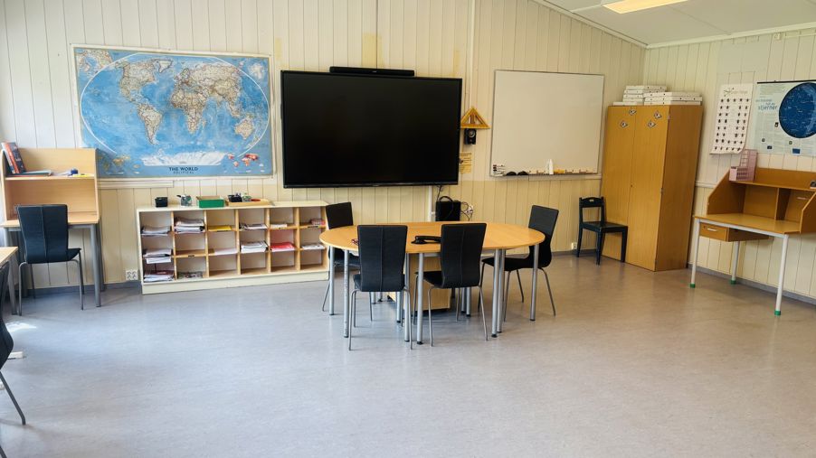 et klasserom med pulter og stoler