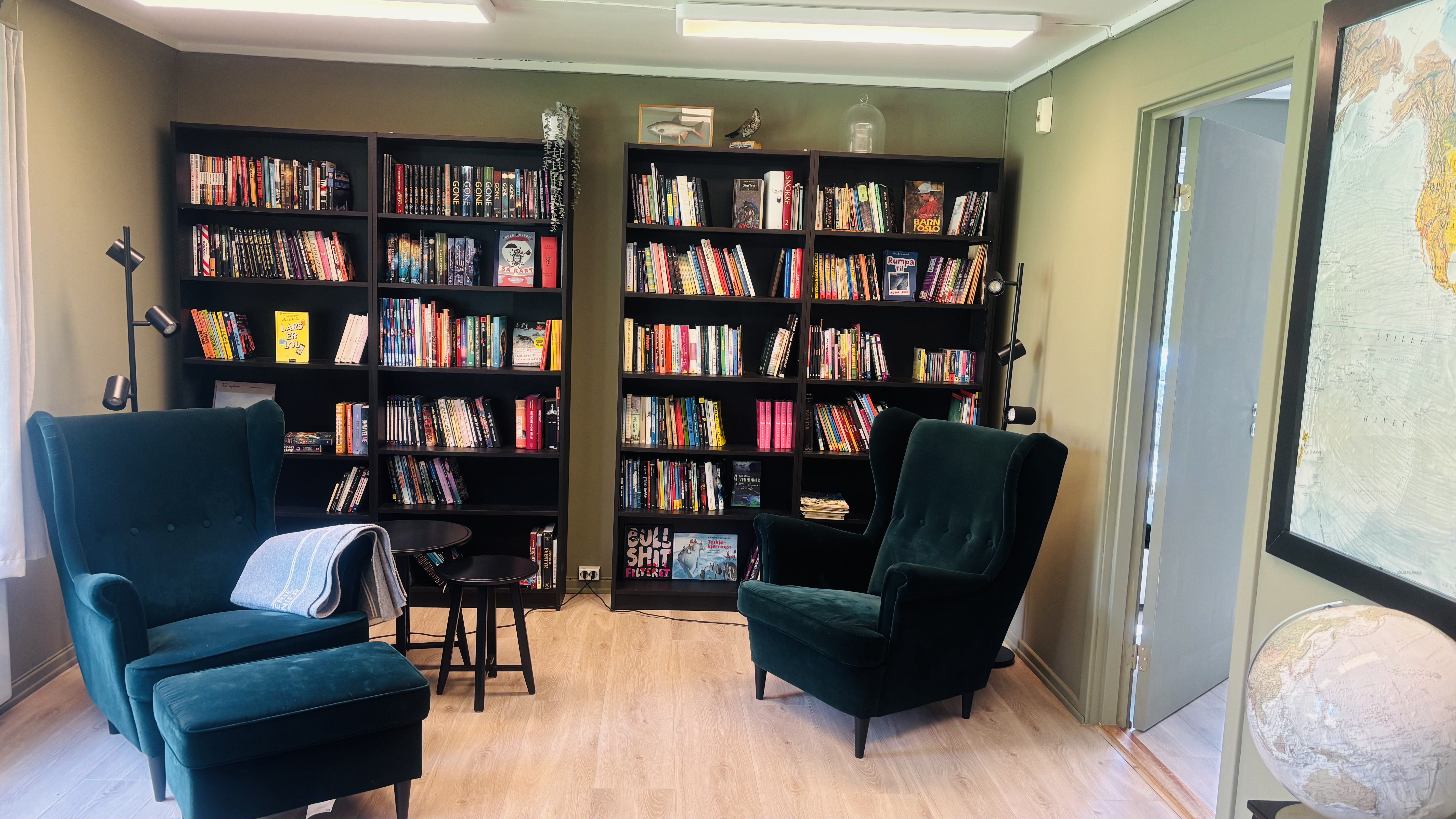 a room with a bookcase and chairs