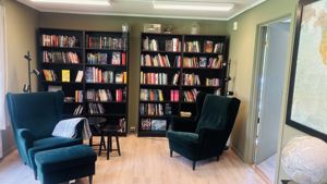 a room with a bookcase and chairs