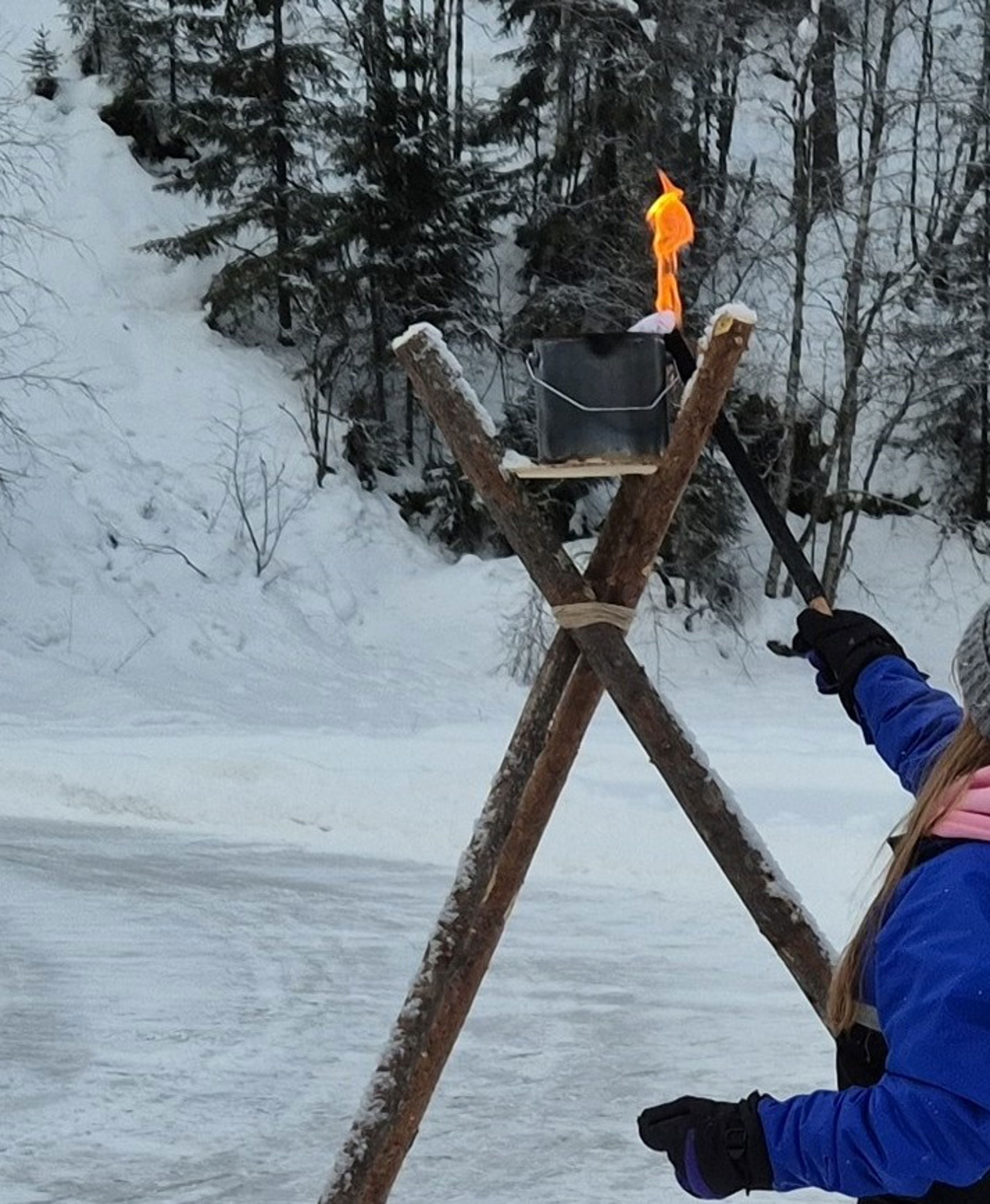 en person som står på en trestang med en bøtte på en person som står på en trestang med en bøtte på