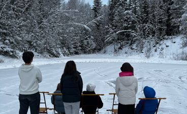 En gruppe mennesker står på snøski