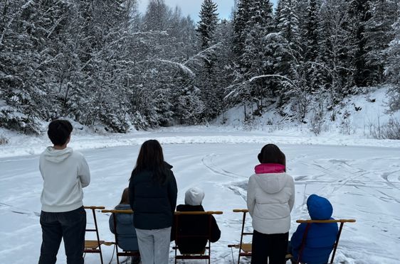 En gruppe mennesker står på snøski
