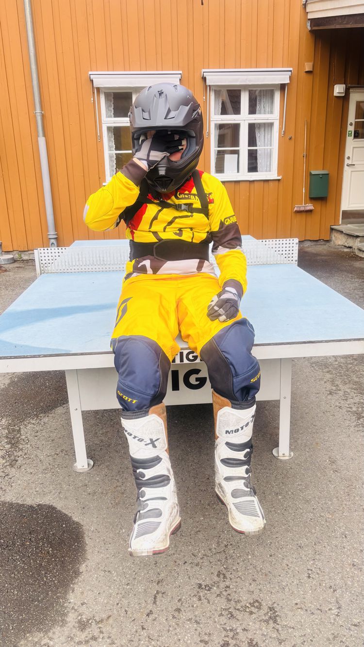 en person iført hockeyuniform og hjelm som sitter på en benk