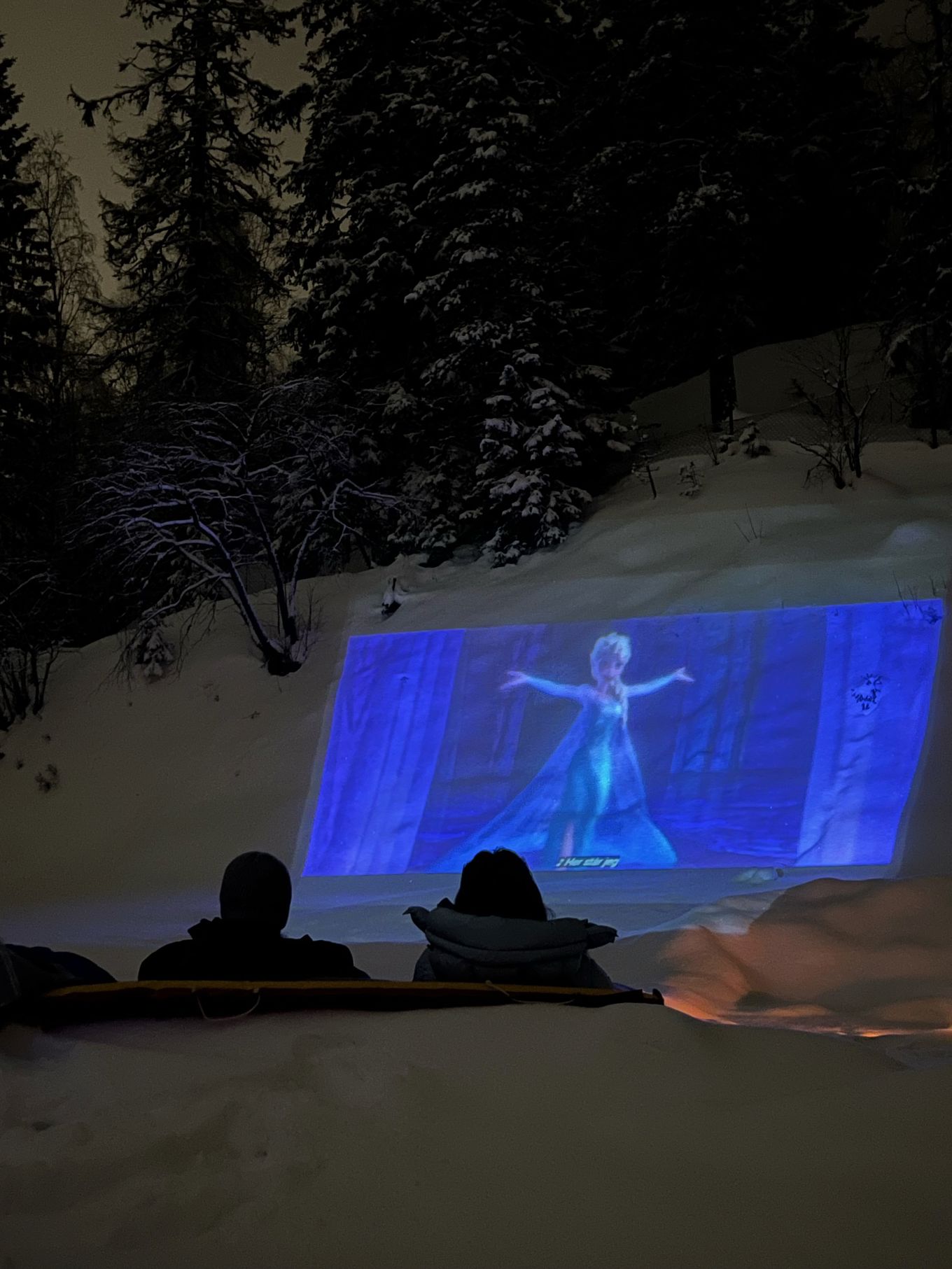 en person som sitter på et teppe i snøen