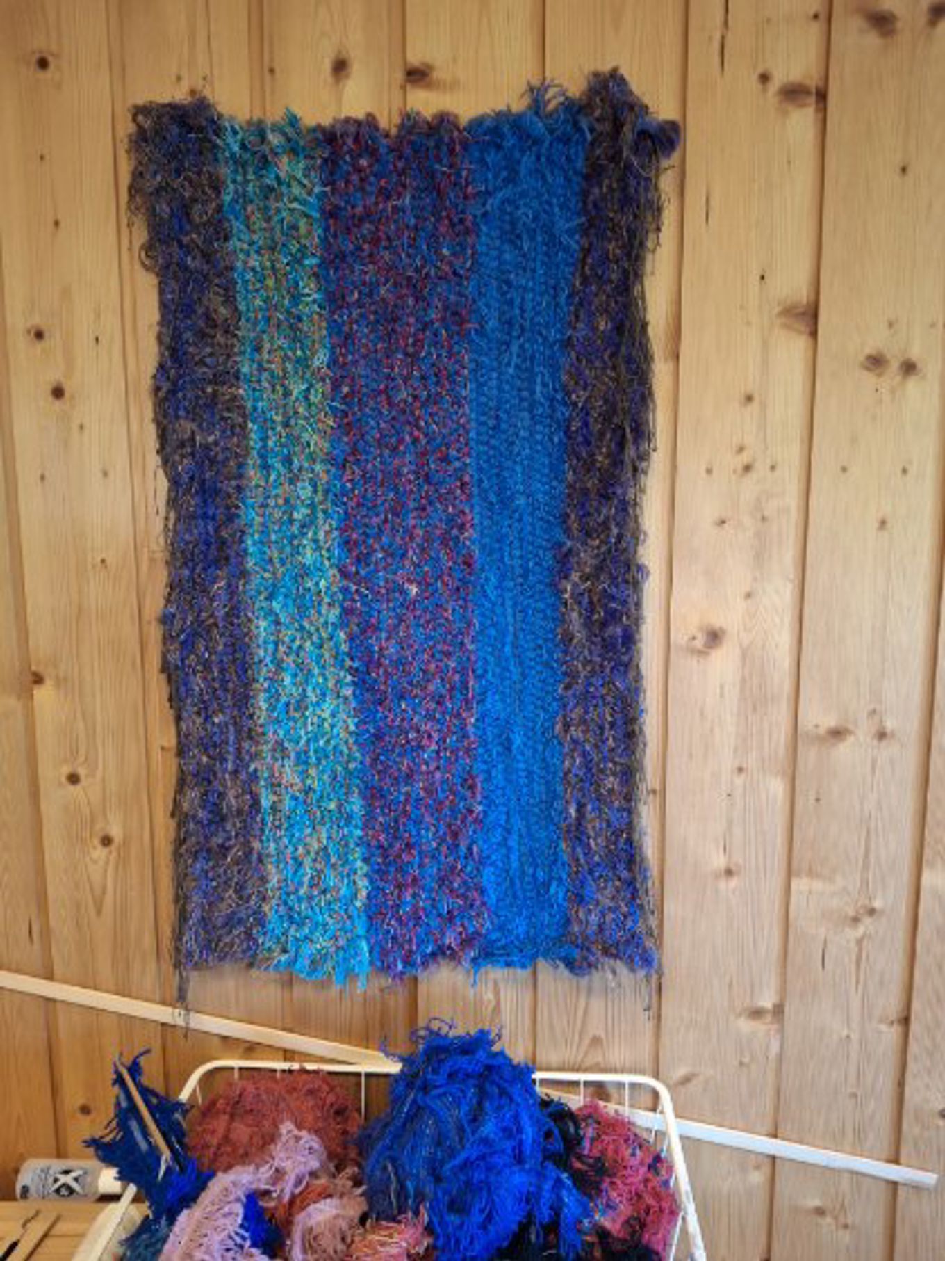 en blå og rød klut på en trevegg